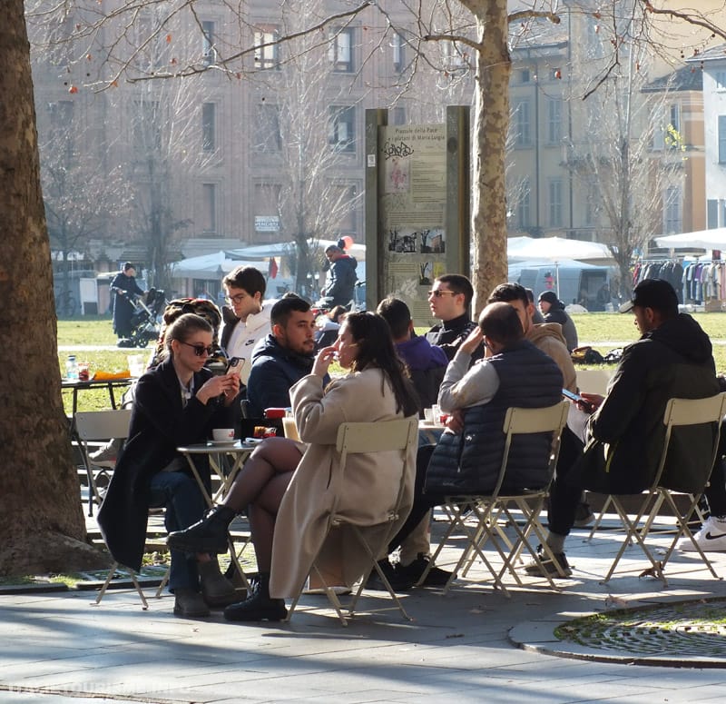 jeunes attablés aux déhors d'un café de Strada Garibaldi, devant la Pilotte ° Parme (Italie)